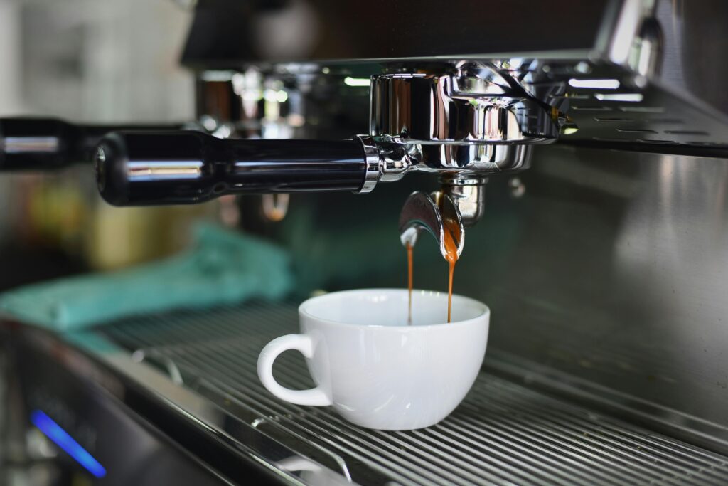 A coffee machine extracting an espresso shot into a white mug